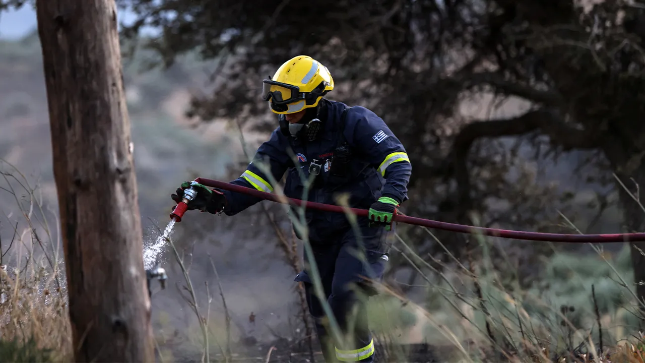 A firefighter works to extinguish a wildfire burning next to the village of Krya Vrysi on the island of Crete, Greece, July 29, 2026. REUTERS/Stringer