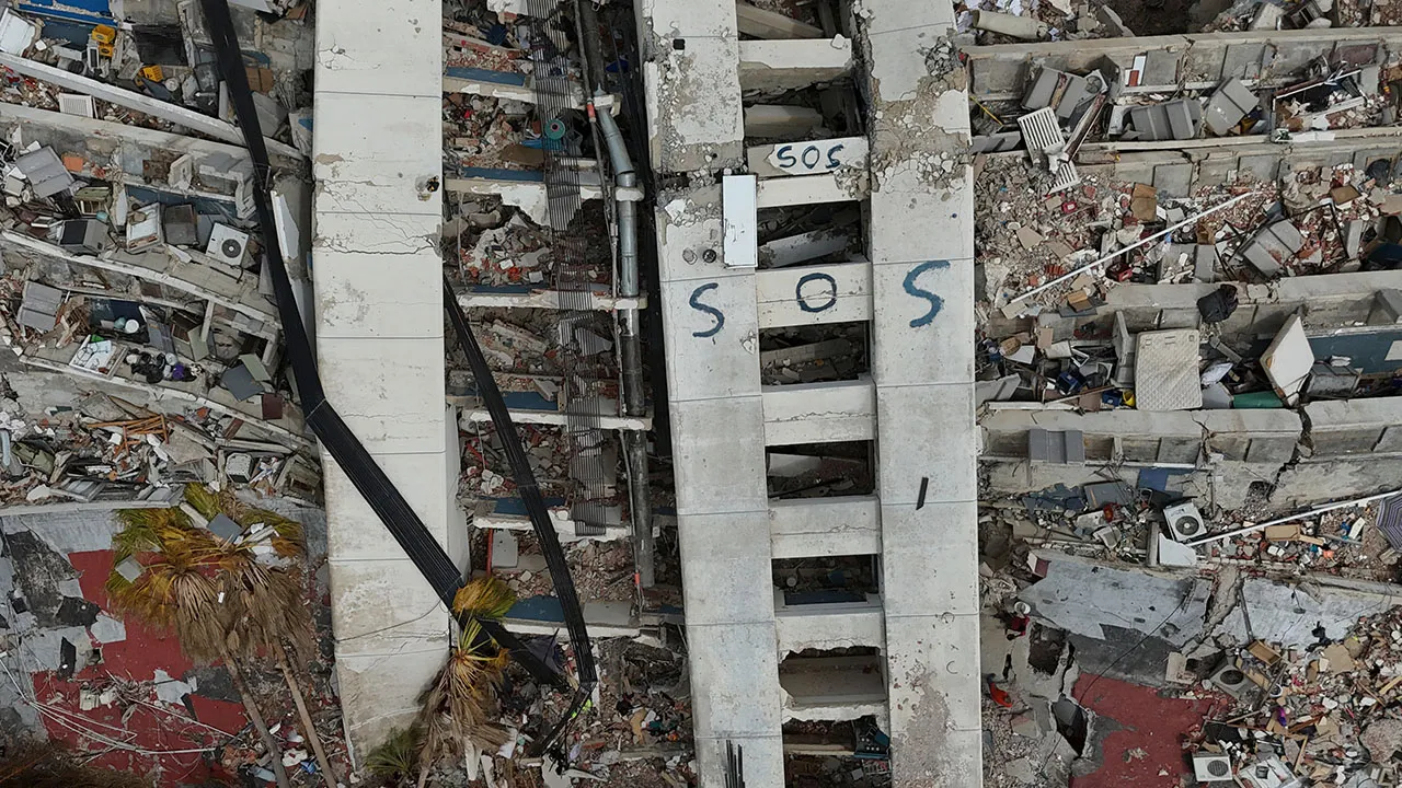 A building damaged during the earthquakes is marked with "S.O.S." painted stands in La Guaira, Venezuela, Thursday, July 2, 2026. (AP Photo/Matias Delacroix)
