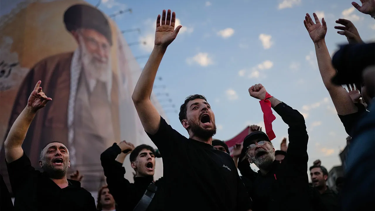 Mourners chant slogans while gathered in Islamic Revolution Square for the funeral procession of the slain Iranian Supreme Leader Ayatollah Ali Khamenei beneath a billboard depicting Khamenei in Tehran, Iran, Monday, July 6, 2026. (AP Photo/Altaf Qadri)