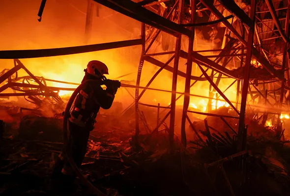 A firefighter works at a compound of a warehouse damaged during Russian missile strikes, amid Russia's attack on Ukraine, in Kyiv, Ukraine July 16, 2026. REUTERS/Valentyn Ogirenko