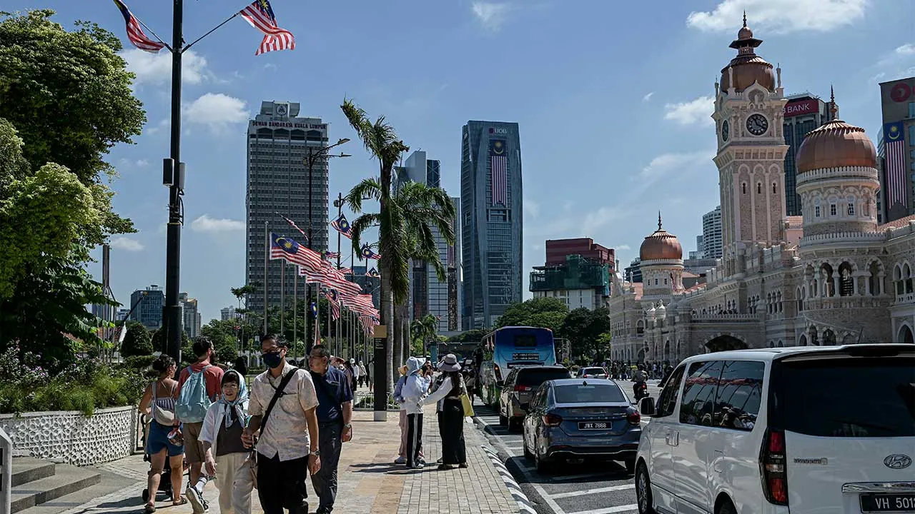 KUALA LUMPUR, 7 Ogos -- Pelancong asing bersiar-siar di sekitar Dataran Merdeka berlatarbelakangkan bangunan yang dihiasi Jalur Gemilang sempena sambutan Hari Kebangsaan yang akan disambut pada 31 Ogos.  -- fotoBERNAMA (2026) HAK CIPTA TERPELIHARA