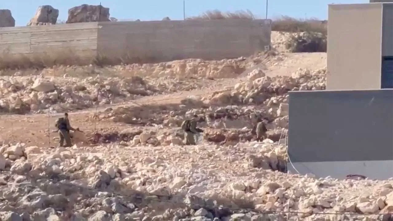 Israeli soliders walk outside a besieged house in Qusra, in the Israeli-occupied West Bank, August 21, 2026, in this screengrab taken from a video obtained by Reuters via REUTERS. Verification lines: Reuters confirmed the location by buildings, fence, road layout and terrain which matched satellite imagery and other videos verified by Reuters. The date when the videos were filmed was verified by Reuters talking to the source. NO RESALES. NO ARCHIVES. THIS IMAGE HAS BEEN SUPPLIED BY A THIRD PARTY.