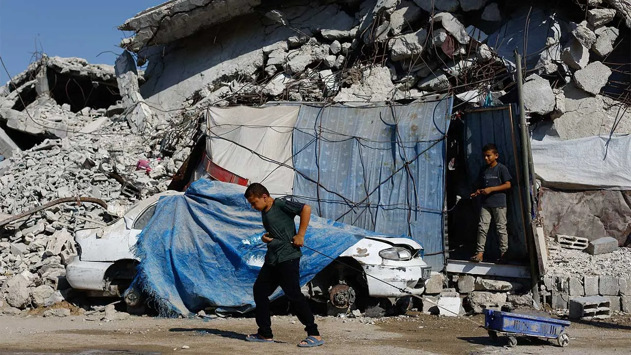 A young Palestinian pulls a wheeled cart near rubble from buildings destroyed during the war, at Jabalia refugee camp in the northern Gaza Strip, August 5, 2026. REUTERS/Mahmoud Issa