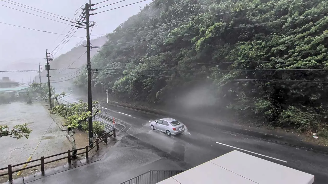 A car makes its way through strong winds and rain as Typhoon Dolphin approaches, in Nazeasahicho, Amami, Kagoshima, Japan, August 7, 2026, in this screengrab obtained from a social media video. @darider5/X/via REUTERS THIS IMAGE HAS BEEN SUPPLIED BY A THIRD PARTY. MANDATORY CREDIT. NO RESALES. NO ARCHIVES. VERIFICATION: - Road layout, buildings, fences and utility poles matched satellite and archive imagery - Date confirmed by original file metadata