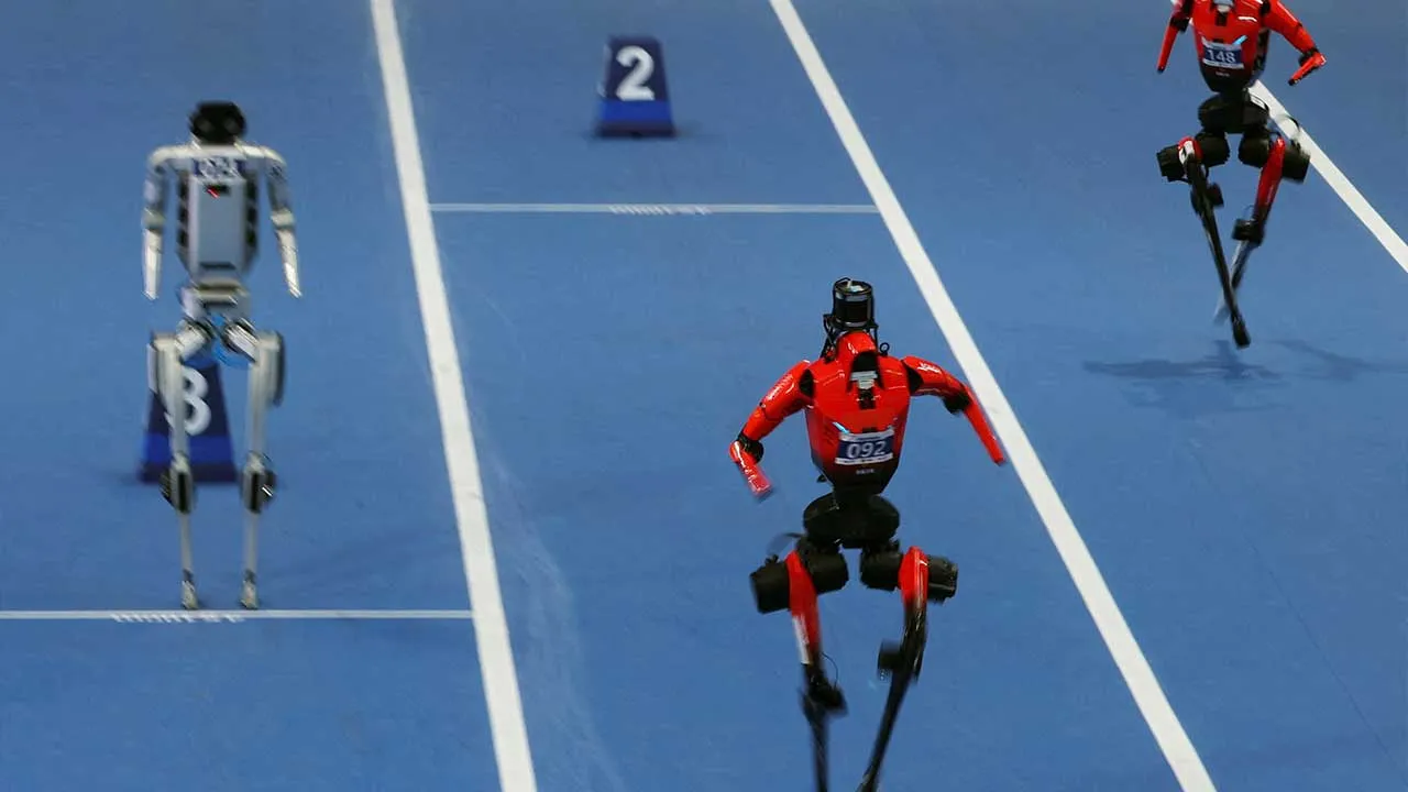Honor's Lightning humanoid robots sprint past a humanoid robot standing still at its starting position as they compete in a 400m large-size group preliminary race, during the second World Humanoid Robot Games at the National Speed Skating Oval in Beijing, China August 22, 2026. REUTERS/Florence Lo