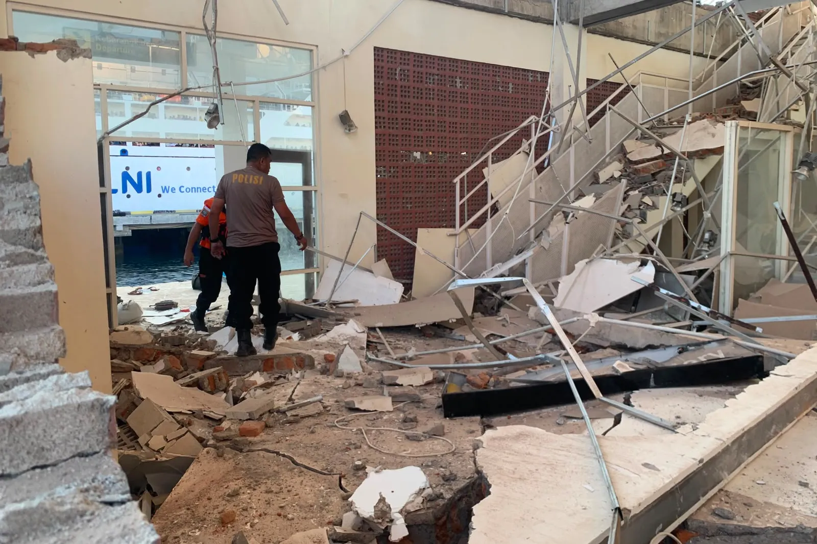 In this photo released by the Indonesian National Search and Rescue Agency (BASARNAS), rescuers inspect a damaged building following an earthquake in Maumere, East Nusa Tenggara Province, Indonesia, Saturday, Aug. 15, 2026. (BASARNAS via AP)