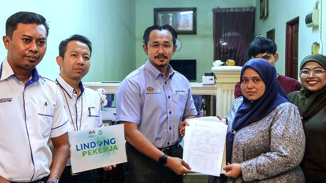 ARAU, 18 Ogos 2026 -- Pengarah PERKESO Negeri Perlis Ahmad Firdaus Hashim (tiga, kiri) menyerahkan Faedah Orang Tanggungan (FOT) PERKESO kepada balu Allahyarham Mohd Fadzil Abdul Karim, Suryani Ishak, 46, di Taman Utara Fasa 2, Arau hari ini.  Allahyarham Mohd Fadzil, 50, yang bertugas sebagai pemandu KTMB Wilayah Utara maut dalam kemalangan di Jalan Kangar-Padang Besar berhampiran Chuping Valley pada 3 Ogos lepas.  Turut hadir Eksekutif Kanan Modal Insan KTMB Wilayah Utara Shahrezat Abd Razak (dua, kiri). 