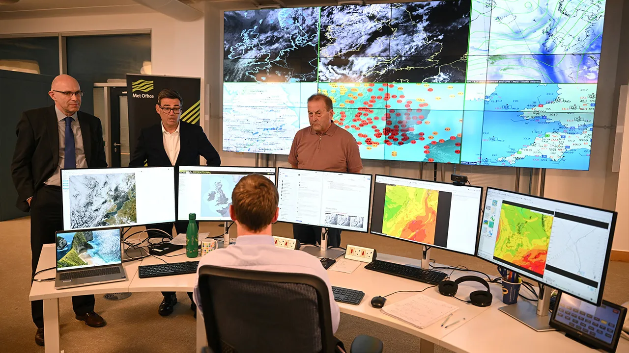 EXETER, UNITED KINGDOM - AUGUST 14: Prime Minister Andy Burnham stands next to Will Lang, chief meteorologist, as he listens to Dan Harris, chief forecaster, at the met office during a visit on August 14, 2026 in Exeter, United Kingdom. Finnbarr Webster/Pool via REUTERS
