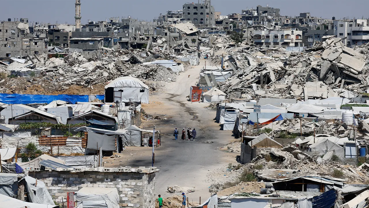 People walk at a site destroyed during the Israeli offensive, in Beit Lahiya, in the northern Gaza Strip, August 18, 2026. REUTERS/Mahmoud Issa