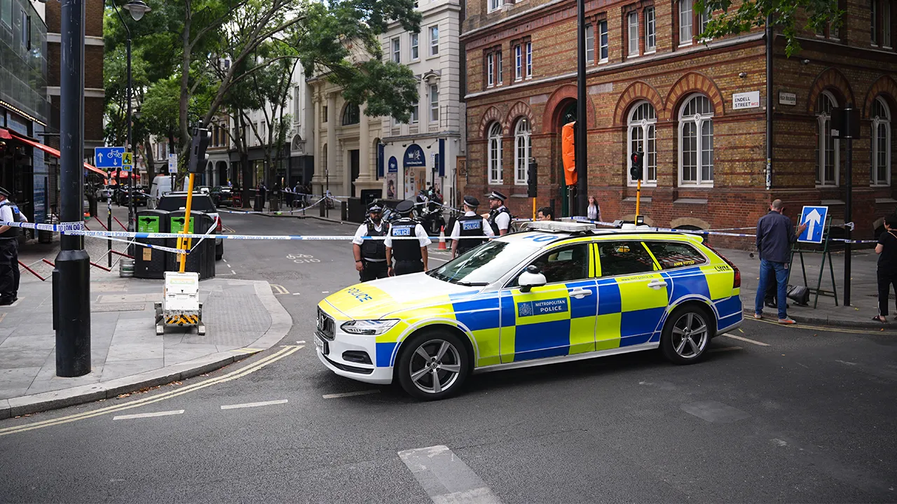 Police officers stand at the scene on Endell Street in Covent Garden, after four men were stabbed, in central London, Wednesday Aug. 5, 2026. PA Photo. (James Manning/PA via AP)