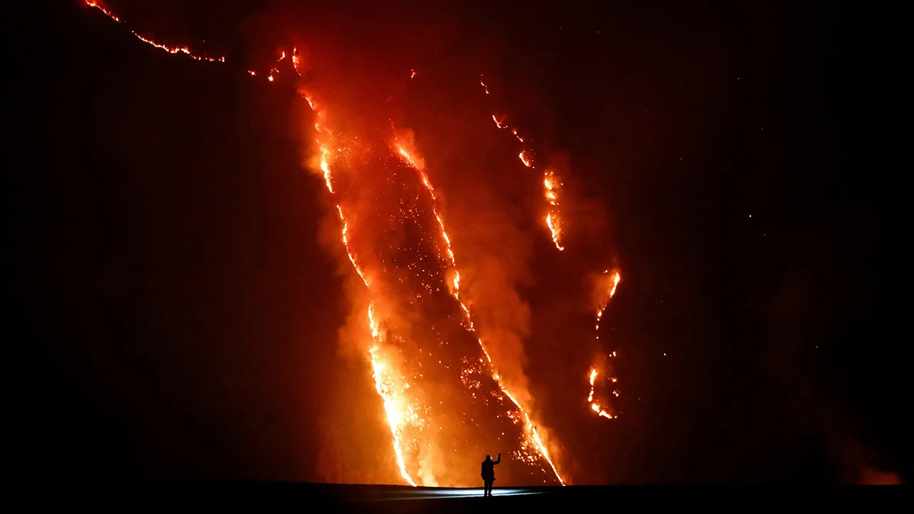 A person observes flames during wildfires on a hill slope in Bromo Tengger Semeru National Park in Probolinggo, East Java province, Indonesia, August 9, 2026. REUTERS/Dipta Wahyu TPX IMAGES OF THE DAY