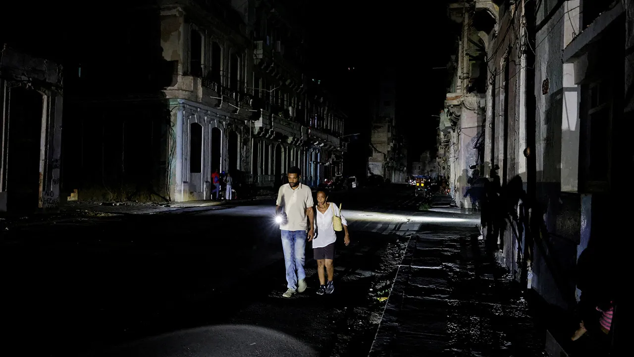 People walk down a street as Cuba's national power grid collapsed, marking the third major outage in nine days, in Havana, Cuba, July 14, 2026. REUTERS/Norlys Perez