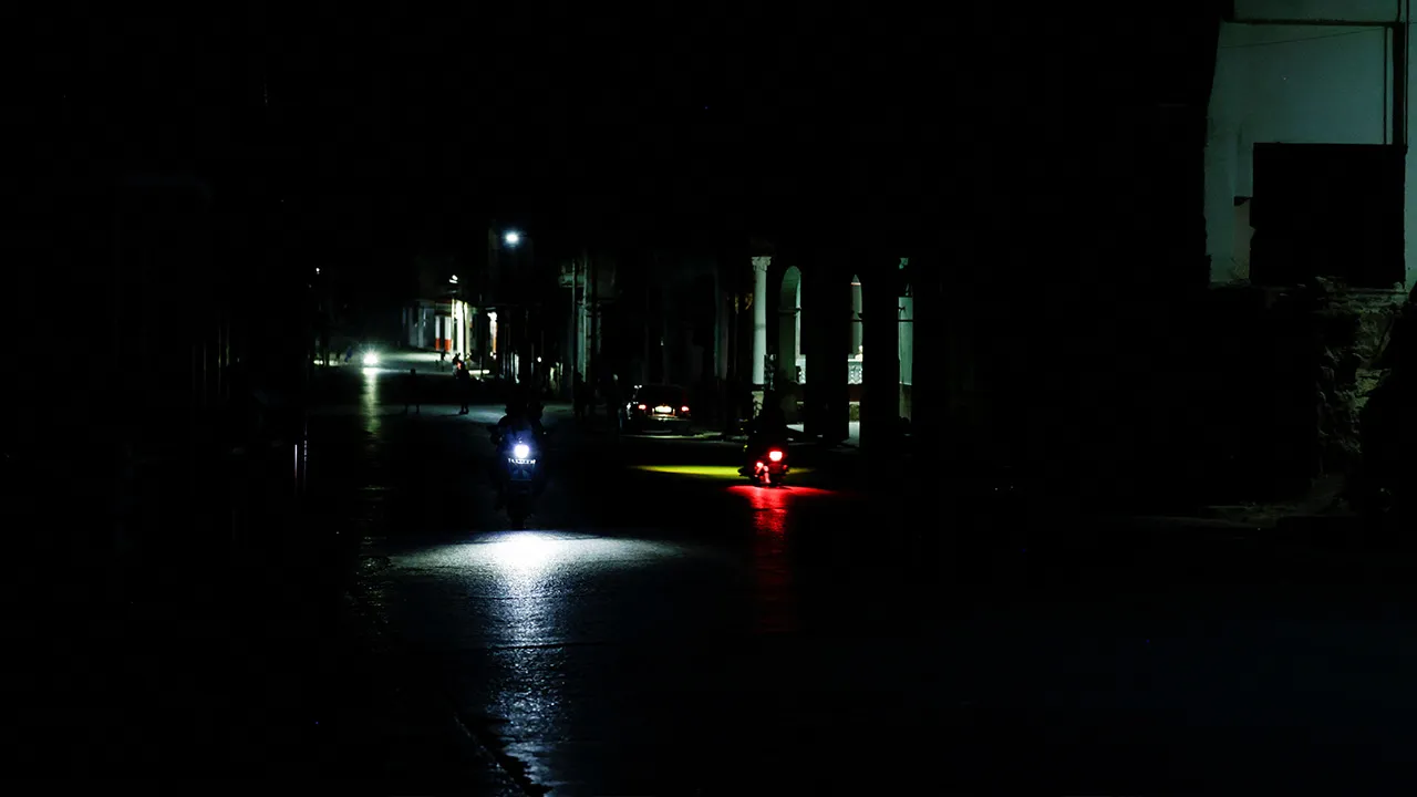 People ride an electric motorcycle through a dark street after Cuba's electricity grid collapsed late on Sunday, plunging the island of about 10 million people into darkness as blackouts become more frequent, in Havana, Cuba, August 3, 2026. REUTERS/Norlys Perez