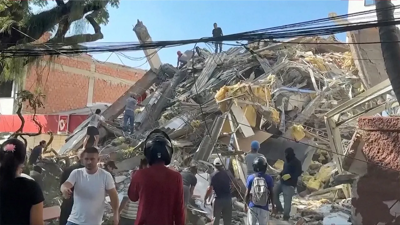 Rescue workers and residents stand around a collapsed building in the aftermath of an earthquake in Cali, Colombia, August 10, 2026 in this screengrab taken from a video. REUTERS/Reuters TV
