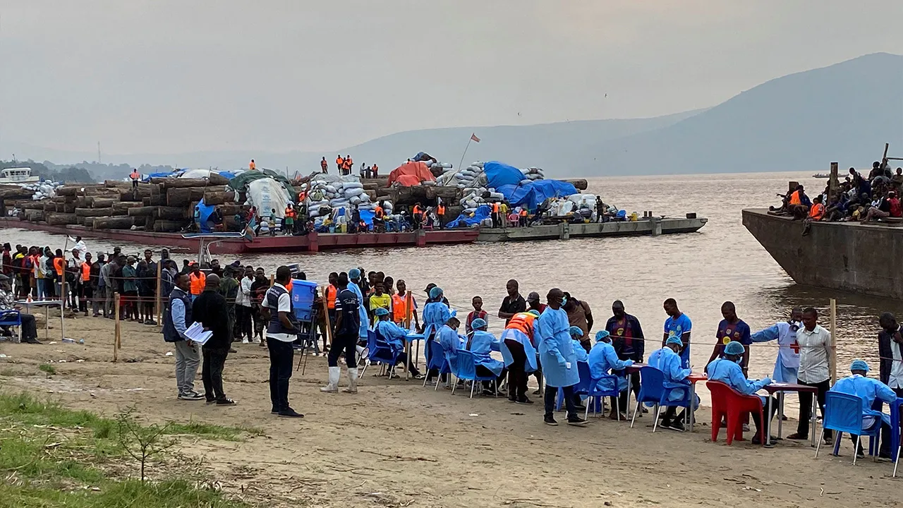 Passengers who disembarked from a boat intercepted by health authorities wait to be tested following the death of a passenger suspected of having Ebola, in Kinshasa, Democratic Republic of the Congo, August 6, 2026. Authorities said the passenger had disembarked earlier in the city. REUTERS/Benoit Nyemba