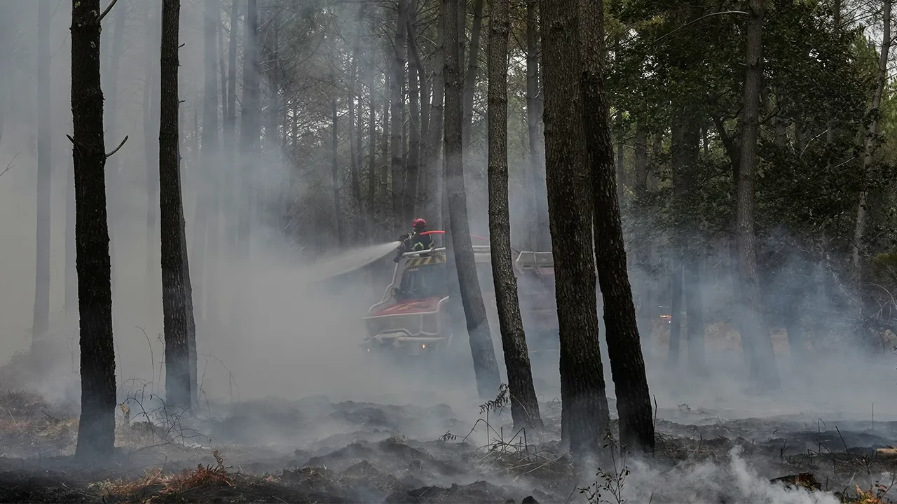 Firefighters work to extinguish a fire, near Blagon, southwestern France, Friday, July 31, 2026. (AP Photo/Baz Ratner)
