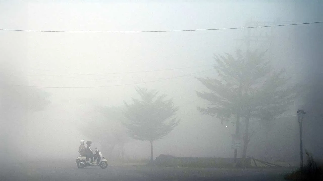 A motorist rides through a road shrouded in haze caused by wildfires in Banyuasin regency, South Sumatra province, Indonesia, August 23, 2026. REUTERS/Abriansyah Liberto