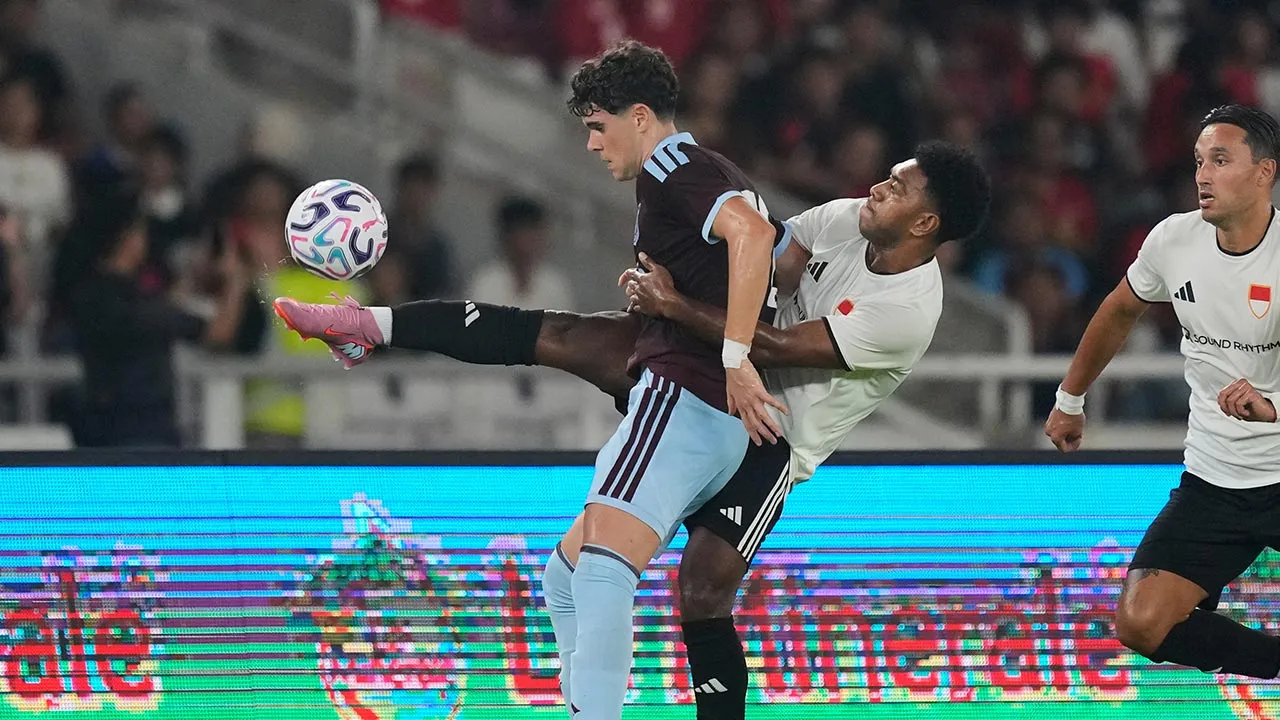 Aston Villa's Kosta Nedeljovic, center, battles for the ball with Indonesia All Stars' Kelly Stroyer during the pre-season friendly soccer match between Aston Villa and Indonesia All Stars in Jakarta, Indonesia, Saturday, Aug. 1, 2026. (AP Photo/Dita Alangkara)