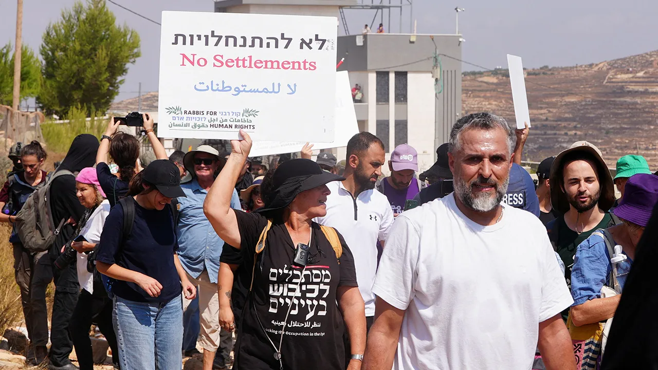 Palestinian, Israeli and foreign activists try to approach a Palestinian house which was besieged by Israeli settlers, in Qusra, in the Israeli-occupied West Bank, August 14, 2026. REUTERS