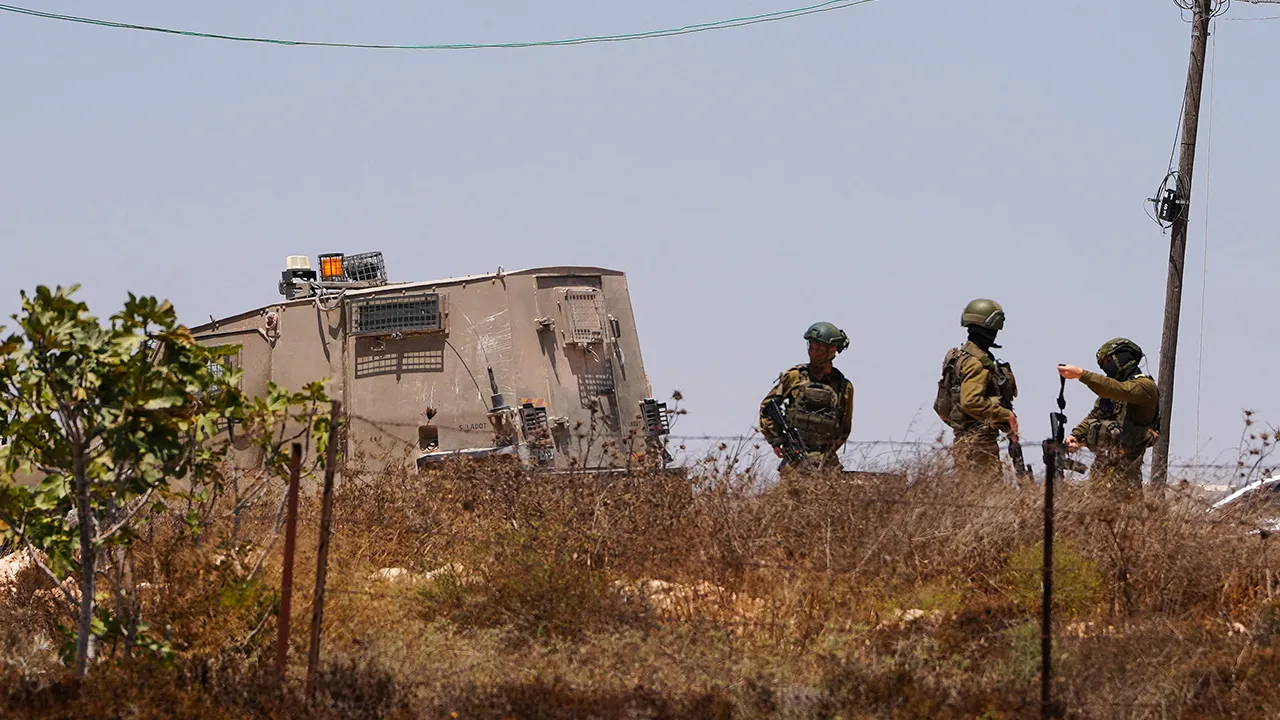 Israeli army soldiers stand near a Palestinian house which was besieged by Israeli settlers in Qusra village in the Israeli-occupied West Bank August 13, 2026. REUTERS