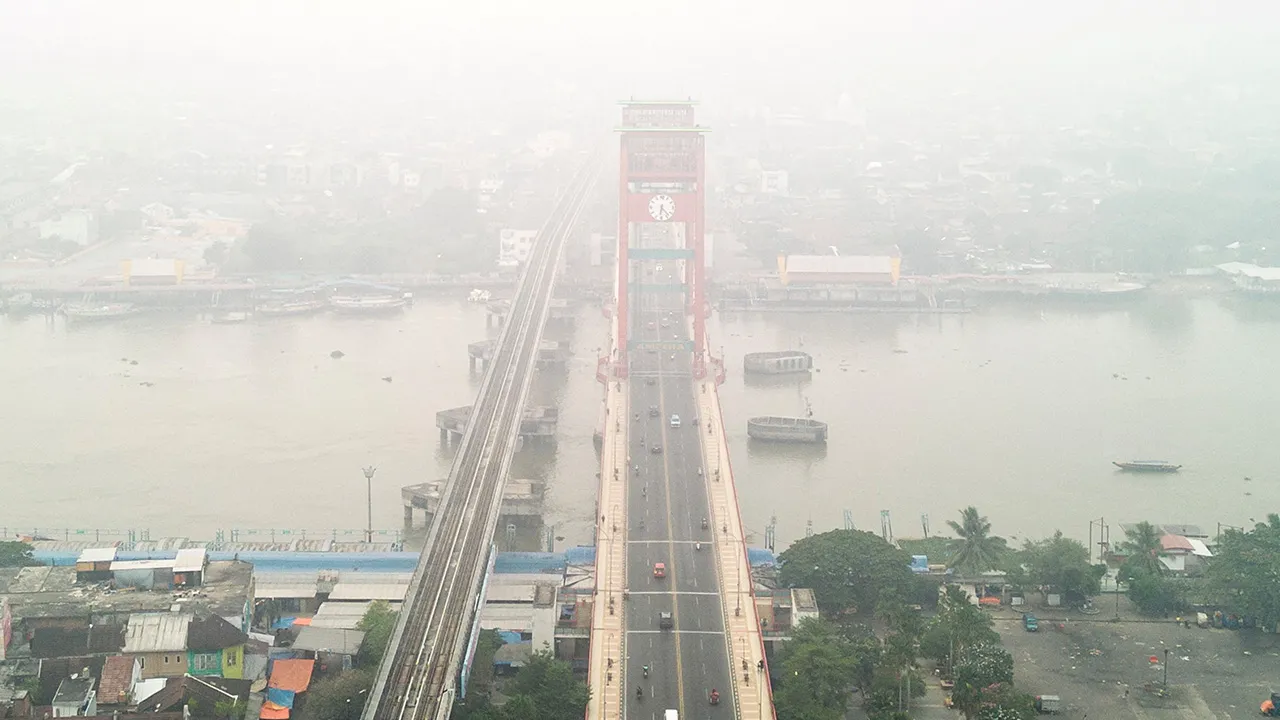 A drone view shows the Ampera Bridge shrouded in haze from wildfires in Palembang, South Sumatra province, Indonesia, August 25, 2026. REUTERS/Abriansyah Liberto