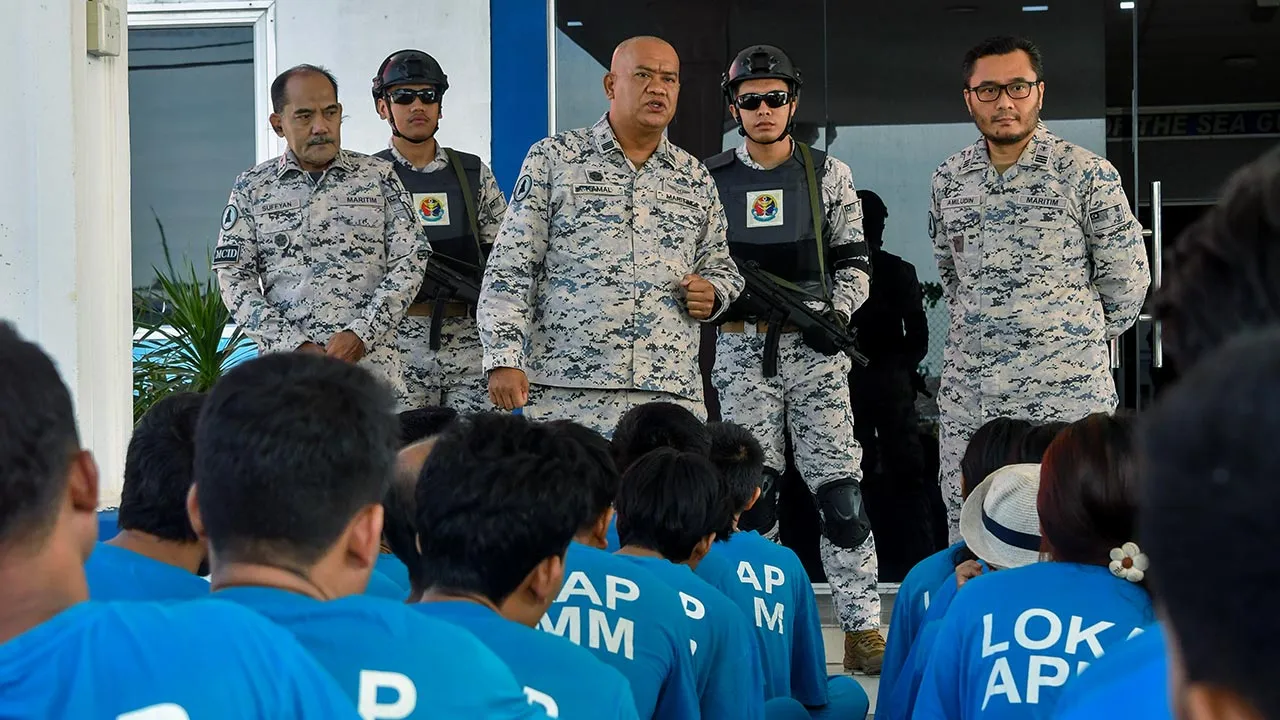 PASIR PUTEH, 26 Ogos -- Pengarah Agensi Penguatkuasaan Maritim Malaysia (APMM) Kelantan Kepten Maritim Kamal Mohamad (tengah) bersama anggota memeriksa pendatang asing tanpa izin (PATI) yang ditahan selepas sidang media di Ibu Pejabat Maritim Kelantan, Tok Bali hari ini.  APMM Kelantan berjaya menahan seorang lelaki tempatan berusia 40 tahun yang disyaki bertindak sebagai tekong darat bersama 37 PATI warga Myanmar dalam operasi Maritim Malaysia Negeri Kelantan di sekitar tebing Sungai Kelantan berhampiran K