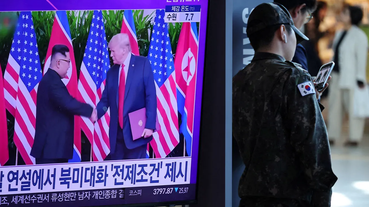 FILE PHOTO: A South Korean soldier stands next to a TV broadcasting a news report on a possible summit between North Korean leader Kim Jong Un and U.S. President Donald Trump, at a railway station in Seoul, South Korea, October 22, 2025. REUTERS/Kim Hong-Ji/File Photo