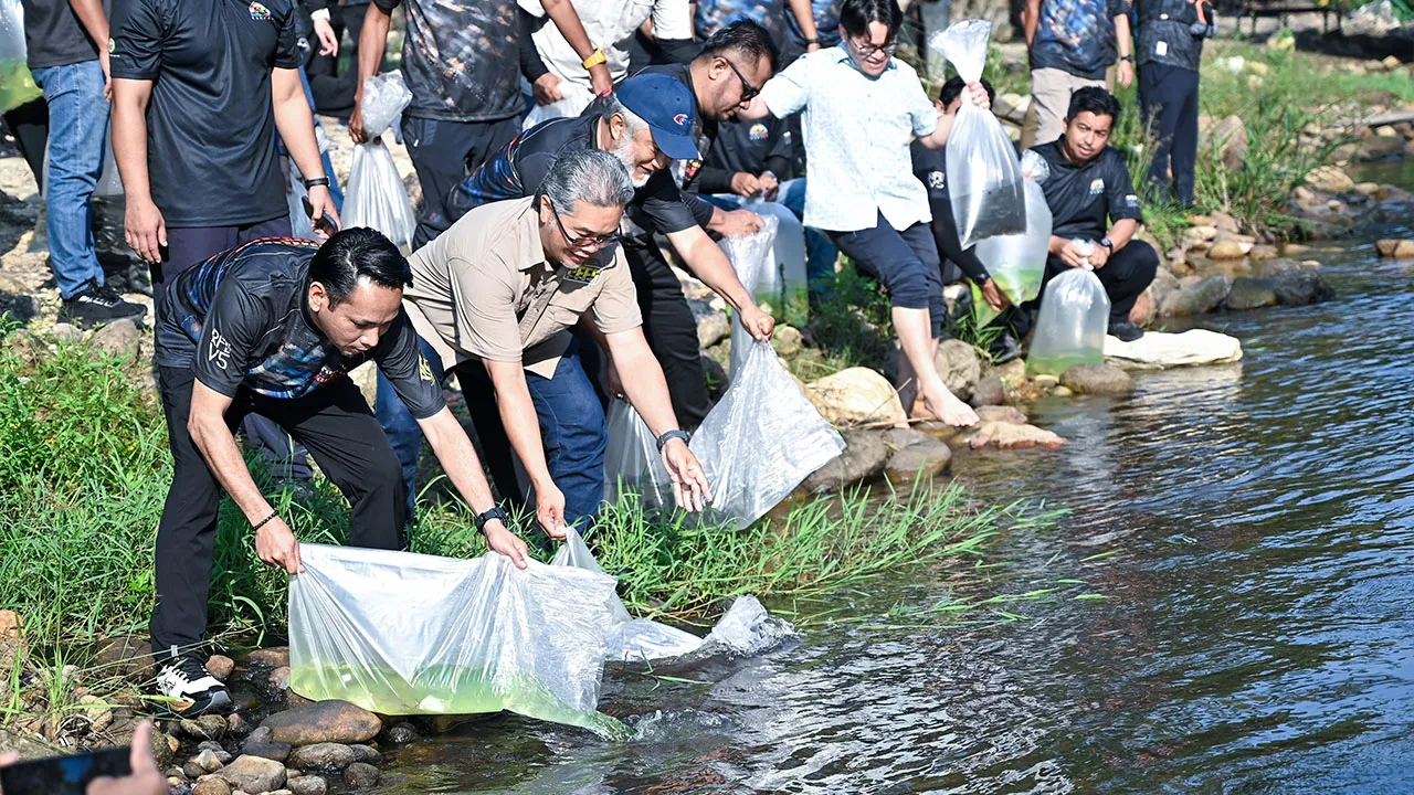 KAMPAR, 22 Ogos -- Pengerusi Jawatankuasa Komunikasi, Multimedia dan NGO Perak Mohd Azlan Helmi (kiri) melepaskan ikan air tawar pada Program "Randuk For Lampam Volume 5" di Sahom Valley Resort hari ini._BERNAMA