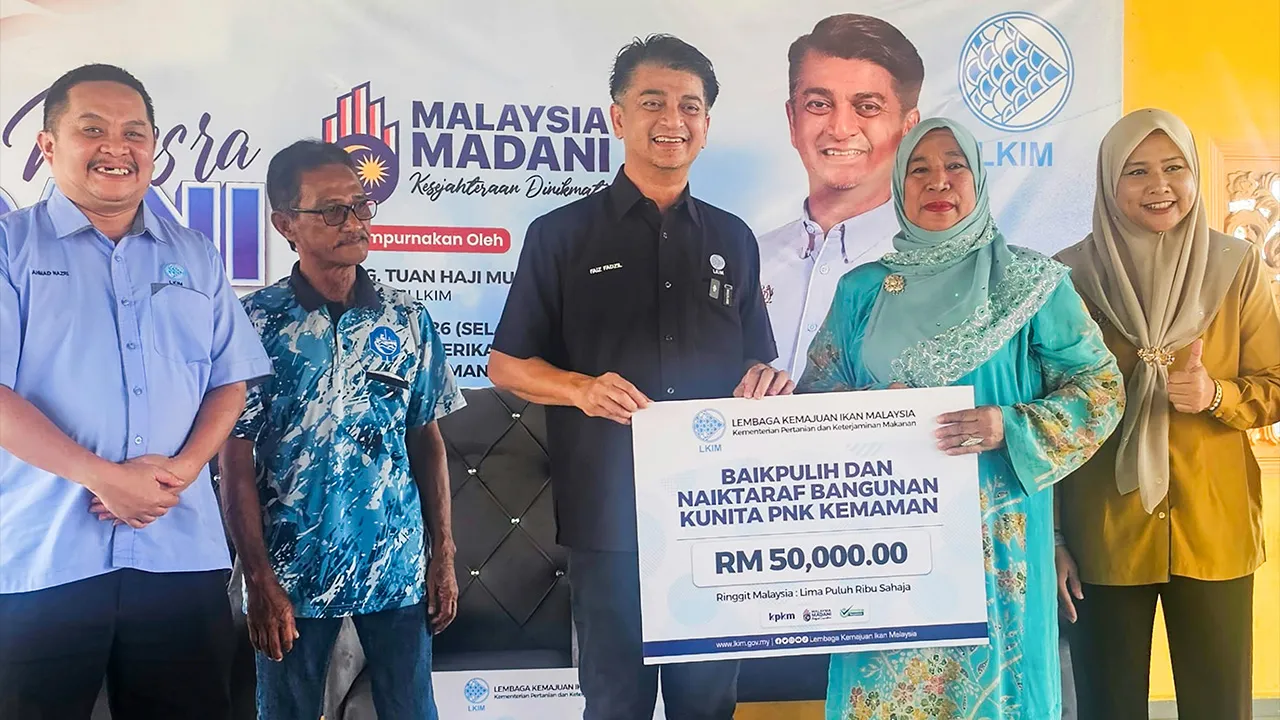 CHUKAI, 18 Ogos -- Pengerusi Lembaga Kemajuan Ikan Malaysia (LKIM) Muhammad Faiz Fadzil (tengah) menyerahkan replika cek kepada Ahli Lembaga Pengrah Persatuan Nelayan Kawsan (PNK) Kemaman, Rohani Awang@Mamat (dua, kanan) pada Program Rahmah Mesra MADANI Pengerusi LKIM Bersama Nelayan Kuala Kemaman di Kompleks Perikanan LKIM Kuala Kemaman hari ini.  Kerajaan menyalurkan peruntukan RM50,000 untuk kerja baik pulih dan naik taraf bangunan Kumpulan Wanita Nelayan (KUNITA) Kemaman bagi menyediakan prasarana perni
