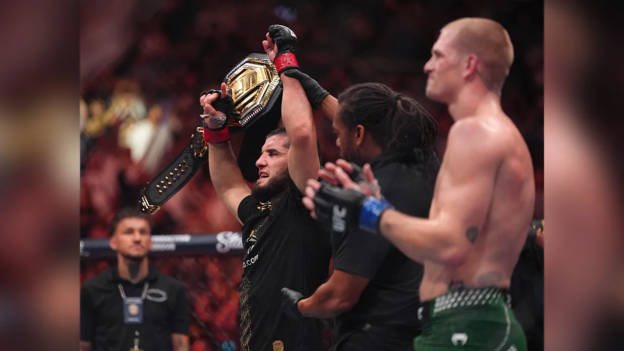 Aug 15, 2026; Philadelphia, Pennsylvania, USA; Islam Makhachev (red gloves) celebrates after defeating Iah Machado Garry (blue gloves) in the welterweight title bout during UFC 330 at Xfinity Mobile Arena. Mandatory Credit: Kyle Ross-Imagn Images