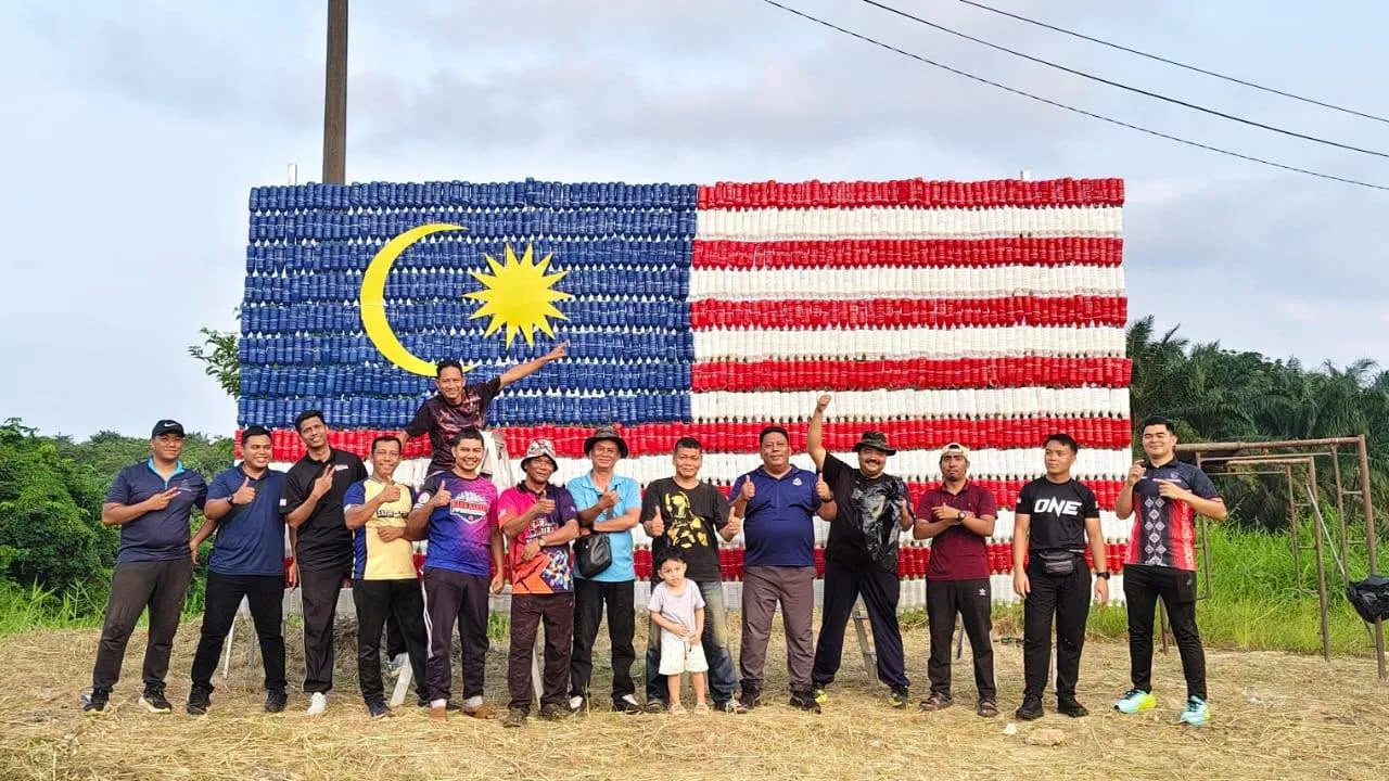#MERSING, 17 Ogos 2026 – Semangat patriotisme dan kreativiti warga PDRM IPD Mersing diterjemahkan melalui penghasilan Arca Jalur Gemilang Gergasi menggunakan sebanyak 1,400 botol mineral terpakai di Kompleks Perumahan Polis KM5, Jalan Jemaluang, Mersing, Johor. Aktiviti yang dilaksanakan secara gotong-royong oleh warga Perumahan Polis IPD Mersing itu mengetengahkan pendekatan kreatif dalam menyemarakkan sambutan Bulan Kebangsaan, selain menerapkan amalan kitar semula dan kelestarian alam sekitar. Sebanyak 1