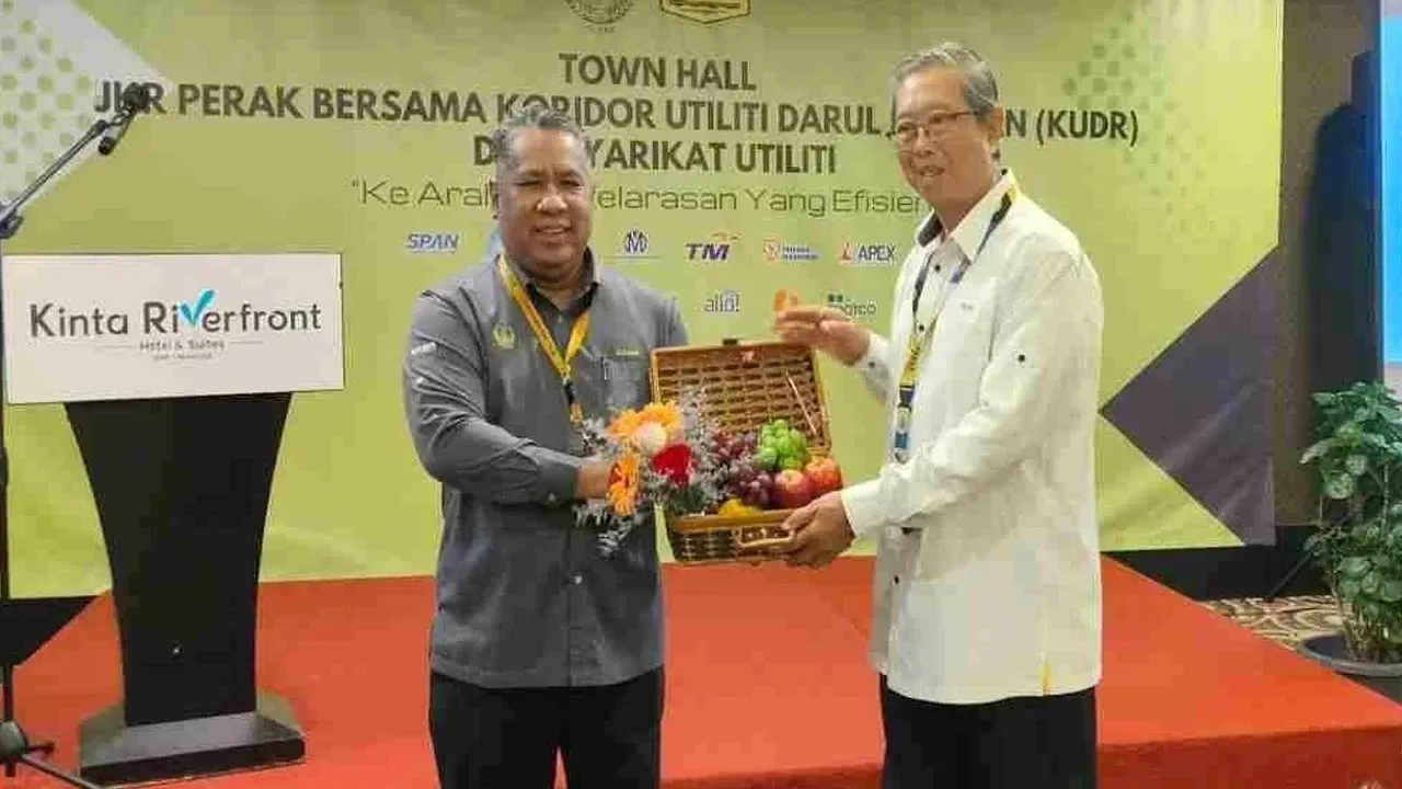 Mohammad Nizar (kanan) menerima cenderahati daripada Zamri selepas merasmikan Program Sesi Town Hall JKR Perak Bersama KUDR dan syarikat utiliti di sebuah hotel di sini pada Selasa. -- SINAR HARIAN