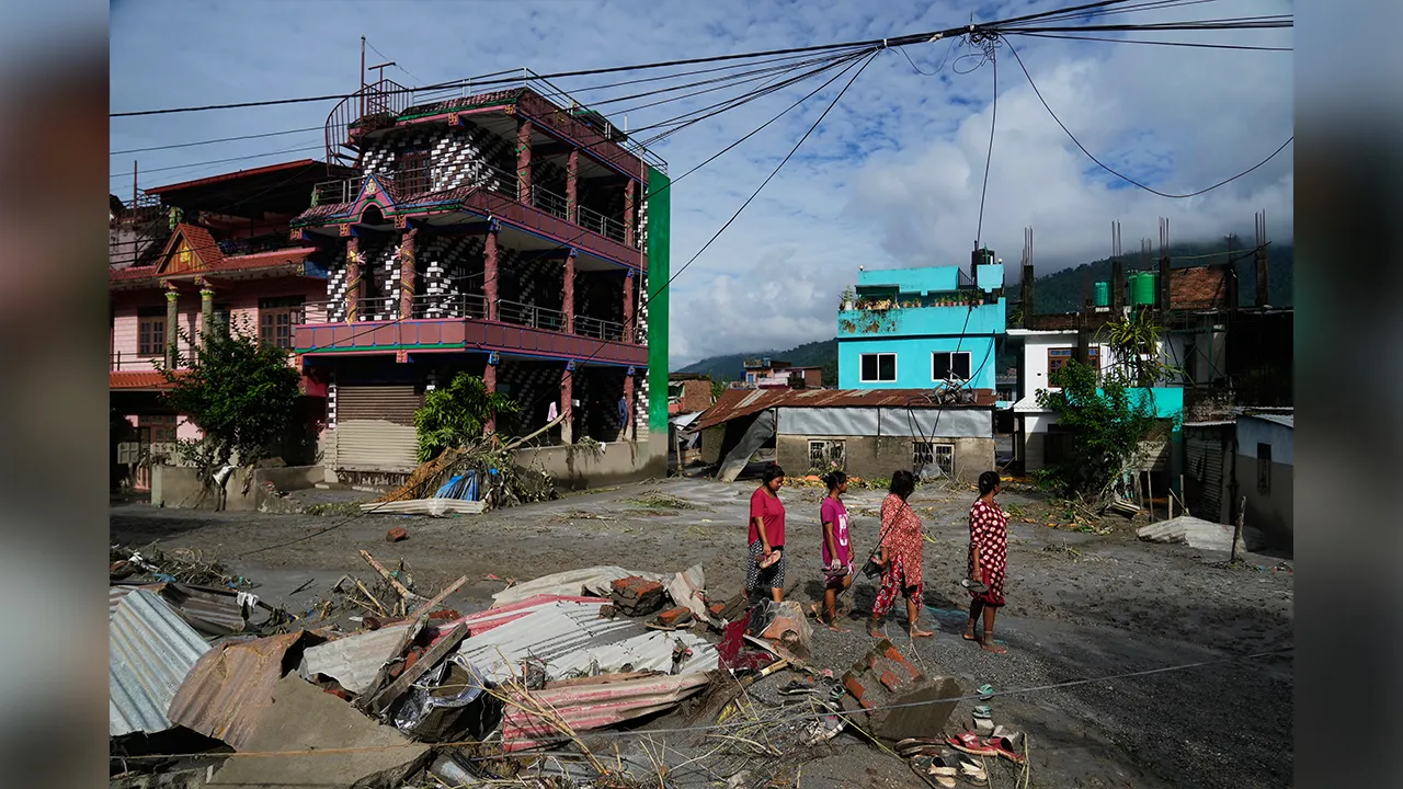 People walk past damage in the aftermath of flash floods in Devighat in the Nuwakot district in Nepal, Thursday, Aug. 27, 2026. (AP Photo/Niranjan Shrestha)