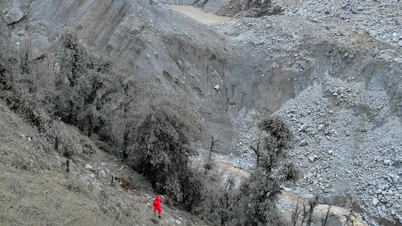 A Chinese rescue worker walks near a barrier lake formed following a mudslide, seen from the Chinese side near the border with Nepal, in Gyirong county, Shigatse, Tibet Autonomous Region, China August 28, 2026. cnsphoto via REUTERS