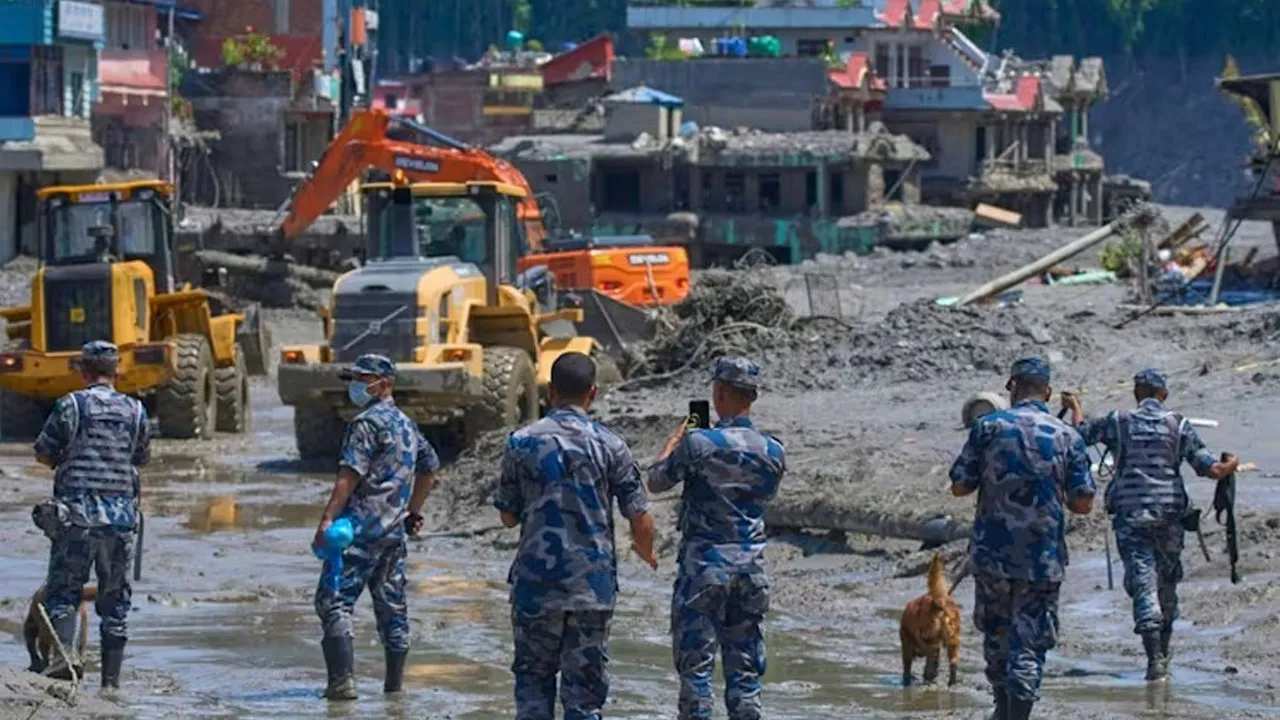 Nepalese policemen watch as earthmovers clear the debris of flash flooding in Nepal's Nuwakot district, Thursday, Aug 27, 2026. (Photo: AP/Niranjan Shrestha)