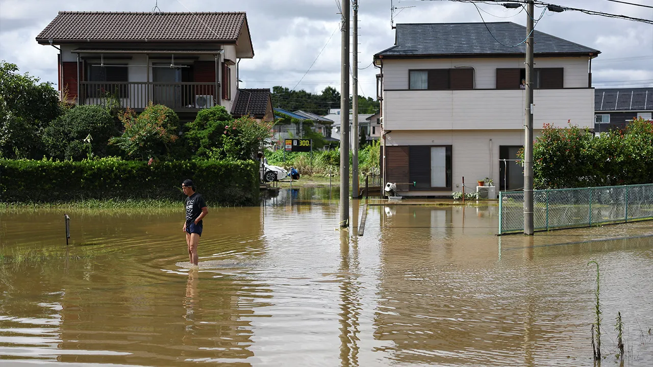 A local resident stands in a flooded area after heavy rain in Oamishirasato, Chiba Prefecture, Japan, August 14, 2026. REUTERS