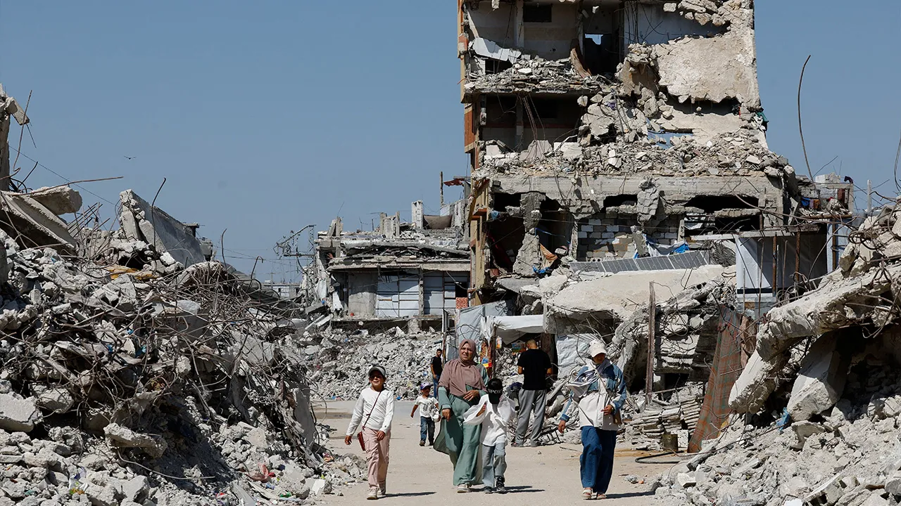 Palestinians walk past the rubble of residential buildings destroyed during the war, at Jabalia refugee camp in the northern Gaza Strip, August 5, 2026. REUTERS