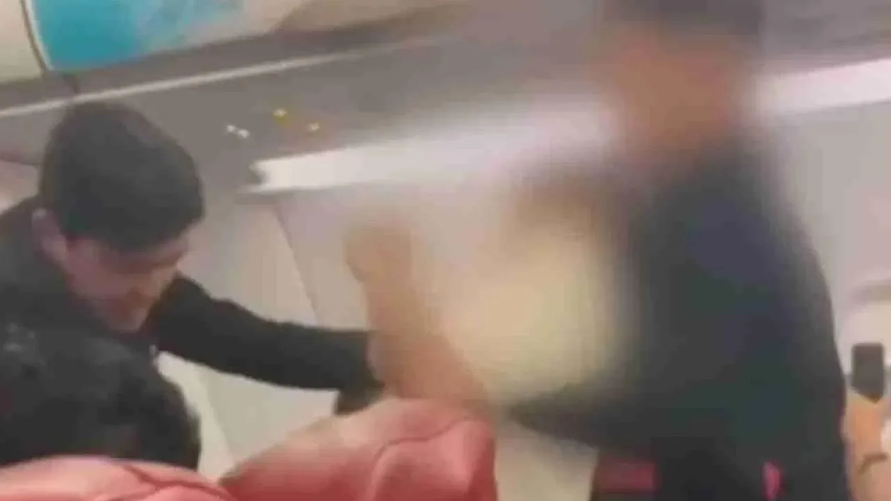 Dua kru kabin lelaki menahan seorang lelaki yang kemudiannya disahkan sebagai seorang leftenan dalam Tentera Diraja Thailand dan mempunyai masalah kesihatan mental. – Foto: Tangkap layar halaman Social Hunter 2022. -- SINAR HARIAN