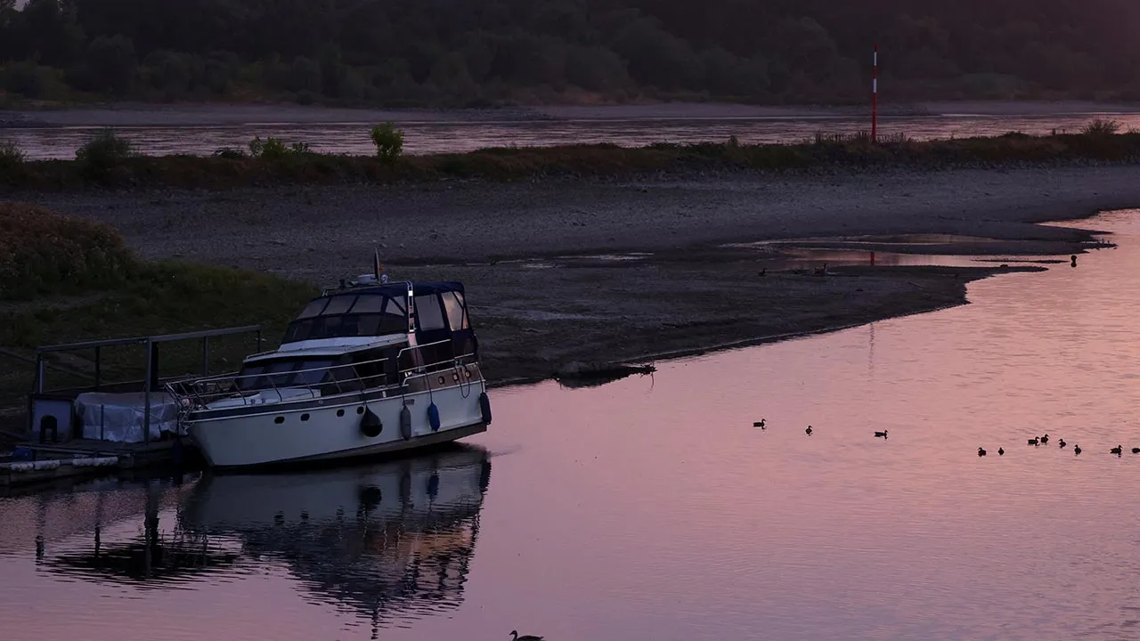 A boat lies in the partially dried-up Hitdorf yacht harbour basin at low water levels of the Rhine River in Leverkusen, Germany, August 3, 2026. REUTERS/Thilo Schmuelgen
