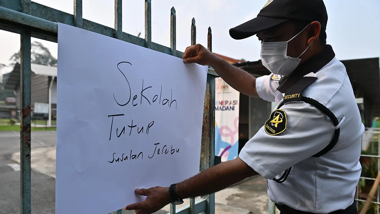 SERIAN, 12 Ogos -- Pengawal Keselamatan Sekolah Kebangsaan Sungai Semera memasang notis yang menyatakan "Sekolah Tutup Susulan Jerebu" melanda kawasan tersebut hari ini._BERNAMA