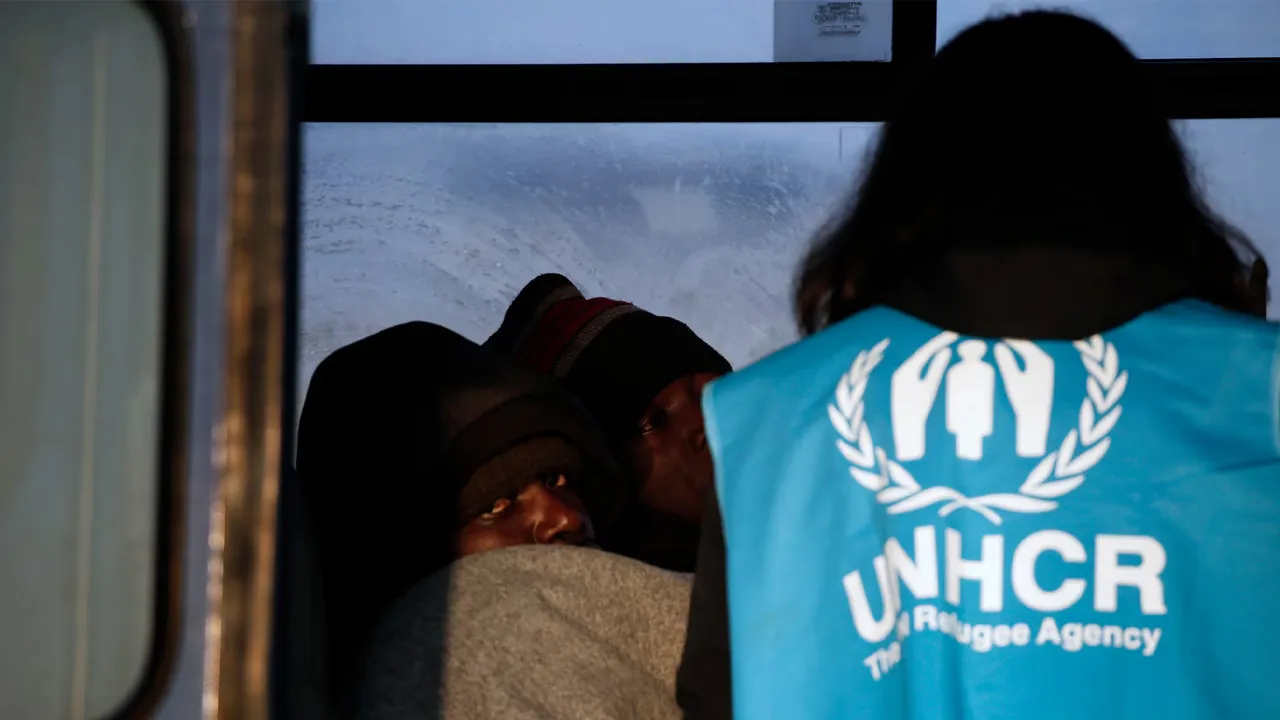 A Congolese refugee looks on as a UNHCR volunteer checks on refugees and migrants rescued at open sea and waiting to be transferred to the Moria registration centre at the port of Mytilene on the Lesbos island, Greece March 21, 2016. REUTERS/Alkis Konstantinidis/file Photo