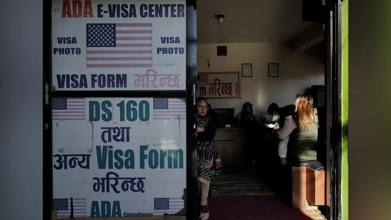 A woman holding a child waits to fill out a U.S. visa application form at a consultancy that assists with visa paperwork in Kathmandu, Nepal, November 28, 2025. REUTERS/Navesh Chitrakar