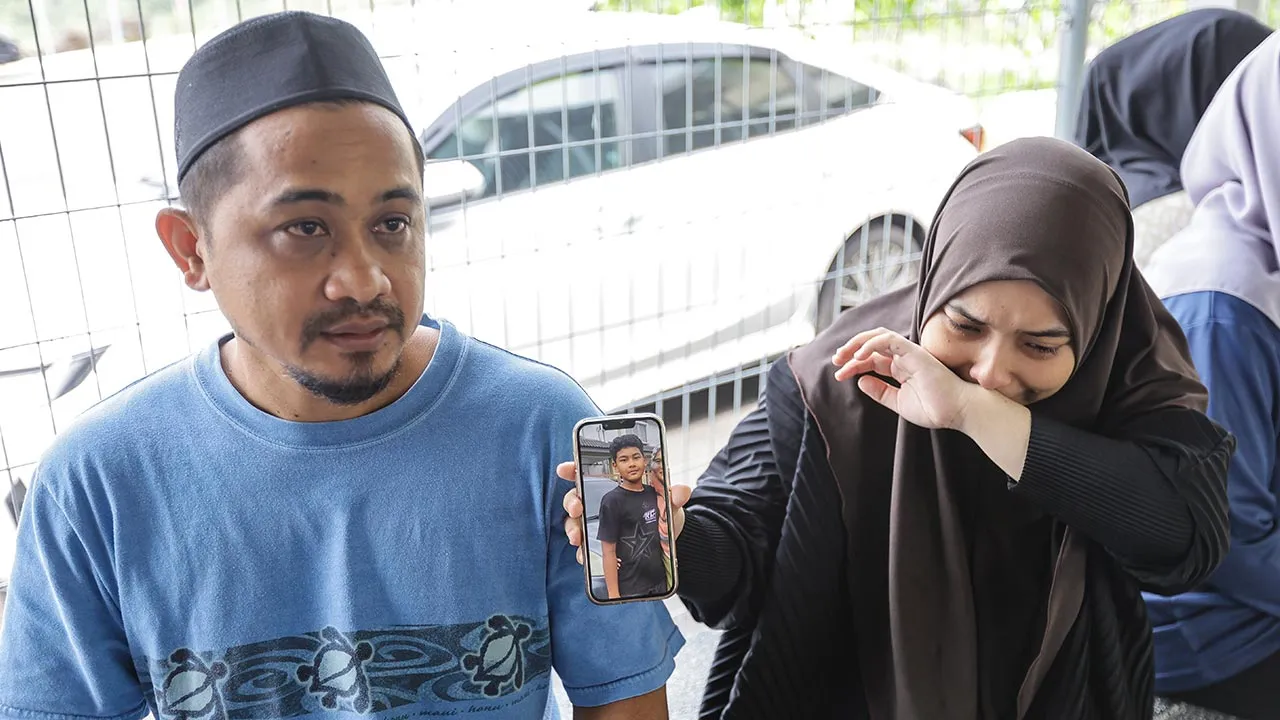 JOHOR BAHRU, 10 Ogos -- Bapa mangsa, Mohamad Khairudi Setapa, 42, (kiri) bersama kakak mangsa, Nur Ain Natasya, 17, yang tidak dapat menahan sebak ketika menunjukkan gambar Mohammad Haikal Ramzi, 12, yang dilaporkan hilang sejak petang semalam, ditemukan lemas di kawasan empangan di Jalan Murai 2, Taman Scientex, Pasir Gudang, awal pagi tadi.  --fotoBERNAMA (2026) HAK CIPTA TERPELIHARA