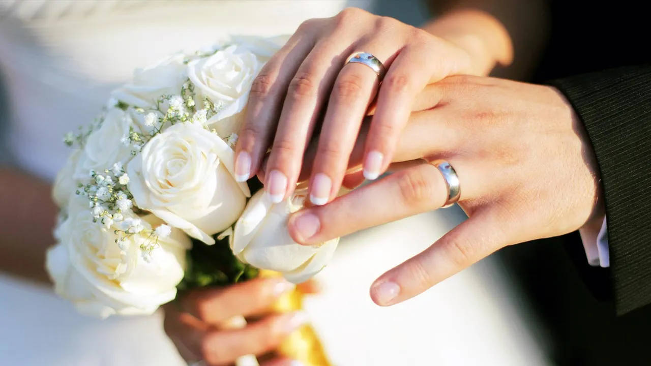Wedding rings and hands -- Adobe Stock