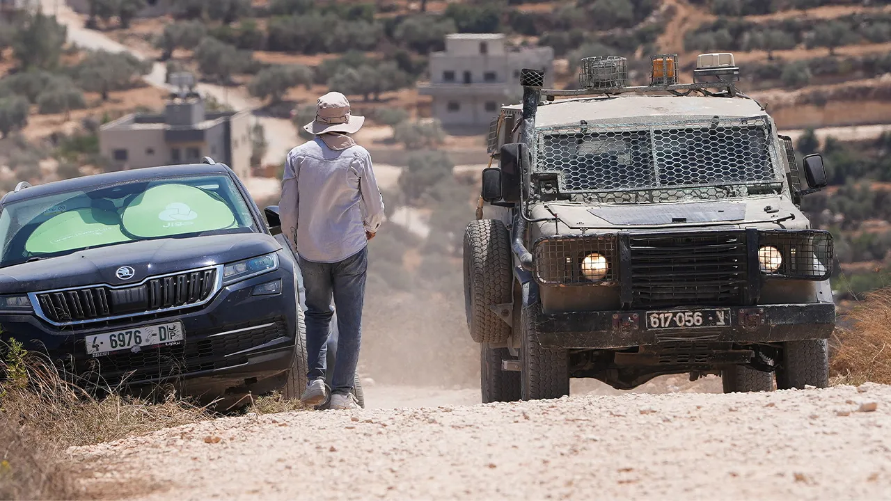 An Israeli army vehicle stands near a Palestinian house which was besieged by Israeli settlers in Qusra village in the Israeli-occupied West Bank, August 13,2026. REUTERS/Ali Sawafta