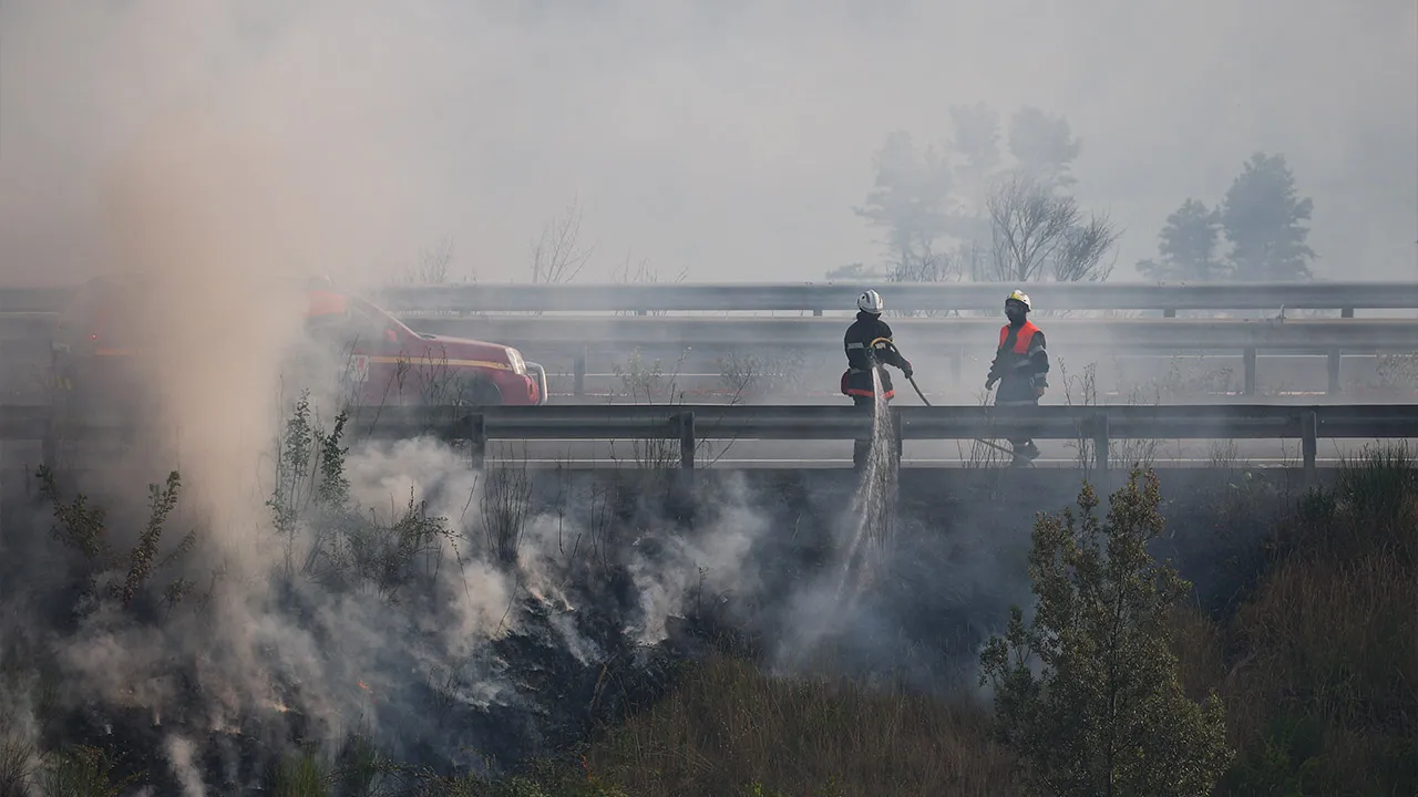 Firefighters use a hose on a burnt area as they battle a wildfire in Carcassonne, Aude department, amid worsening drought conditions following a heatwave and water shortages across much of France, August 2, 2026. REUTERS/Florion Goga