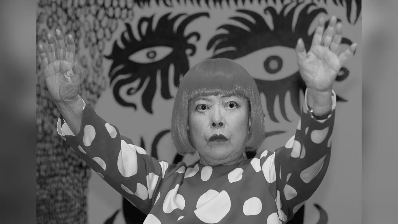 FILE PHOTO: Artist Yayoi Kusama poses for a photograph with a detail from her artwork "Love arrives at the Earth Carrying with it a Tale of the Cosmos" at the Tate Modern gallery in London, Britain, February 7, 2012. REUTERS/Luke MacGregor/File Photo