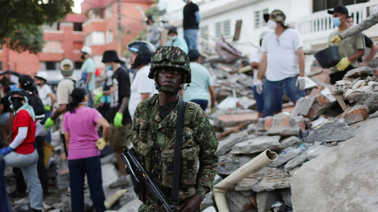 A soldier keeps watch as rescue efforts continue at the site of a damaged building following an earthquake, in Cali, Colombia, August 11, 2026. REUTERS/Raquel Cunha