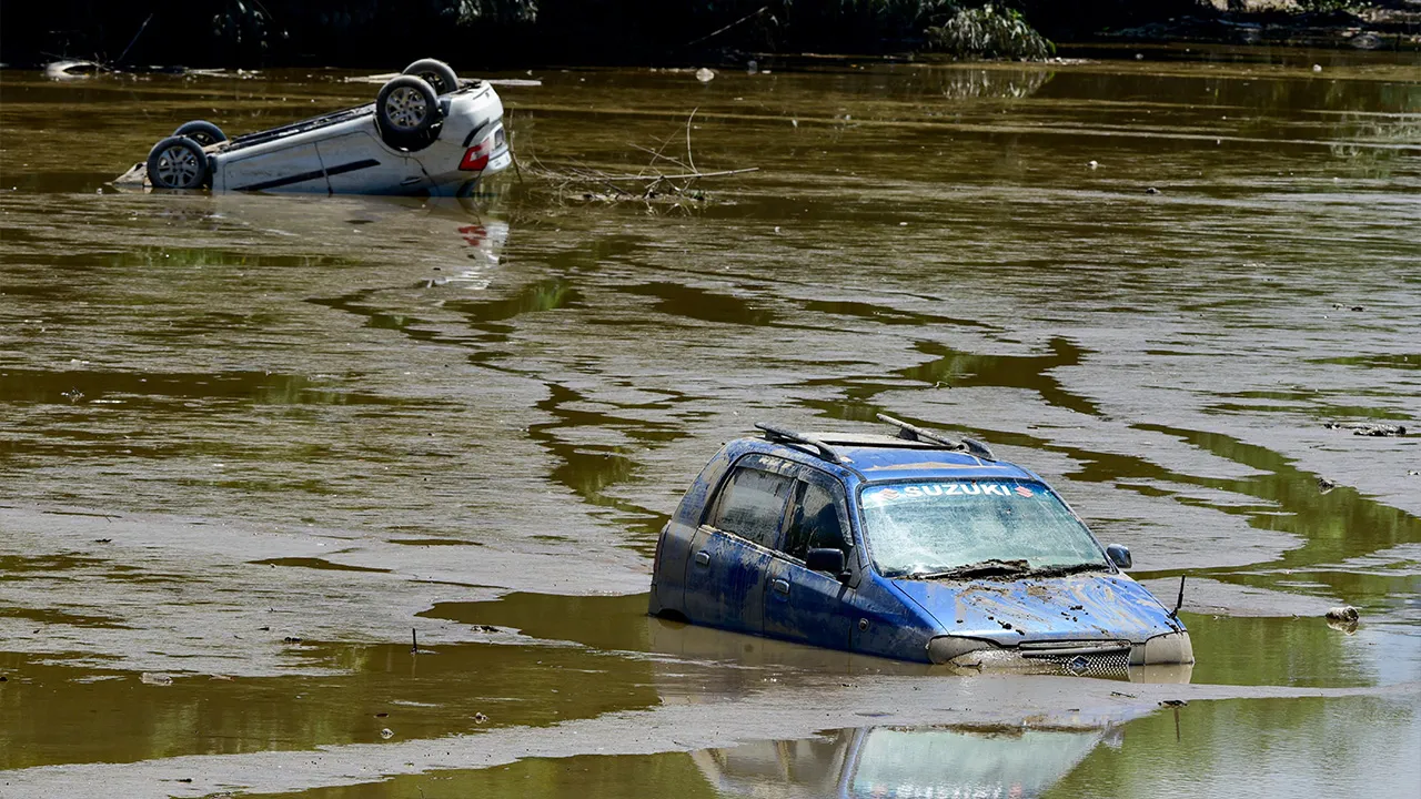 Cars partially submerged in muddy floodwater after a severe flood hit in Sivasagar, Assam, India, July 25, 2026. REUTERS/Hafiz Ahmed
