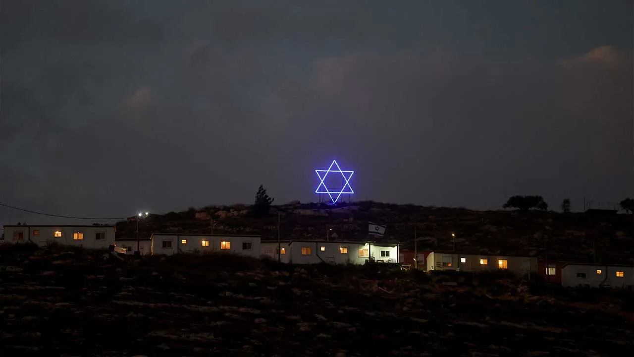 An illuminated Star of David above an Israeli settlers outpost near Ramallah, in the Israeli-occupied West Bank, August 14, 2026. REUTERS/Ammar Awad